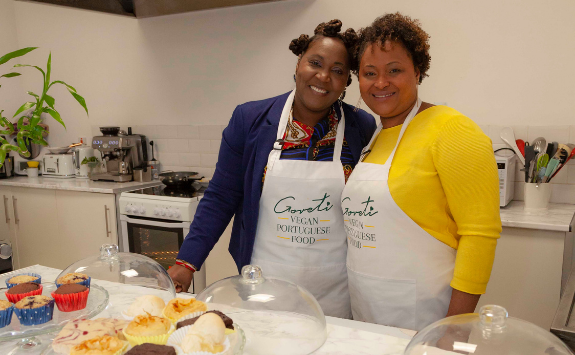 Maria and her colleague pose behind the counter at their cafe, Goreti